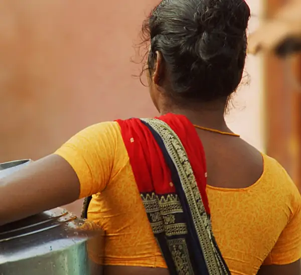 Photo of an Indian woman carrying a large jug