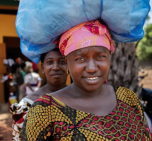 Women leave a bednet distribution site in the village of Timabourou. 