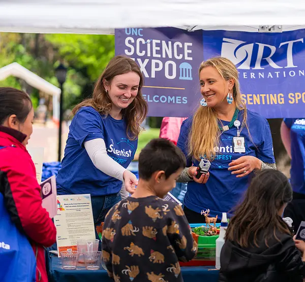 Staff members meet visitors at RTI's booth at the UNC Science Expo in April 2024