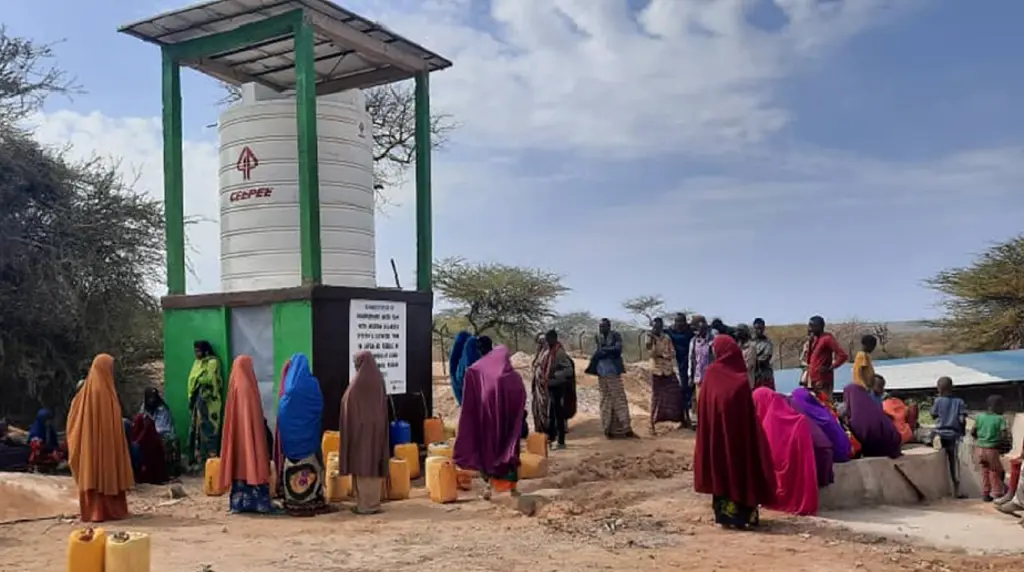 Photo of people gathered around a large water tank in East Africa