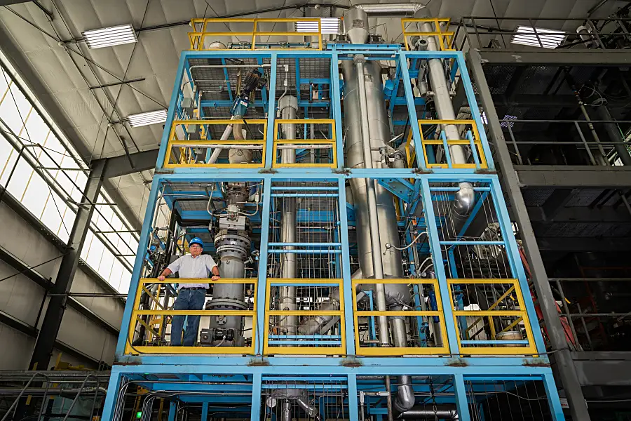 Wide shot of David Dayton standing inside a large piece of equipment in RTI's Energy Technology Development Facility