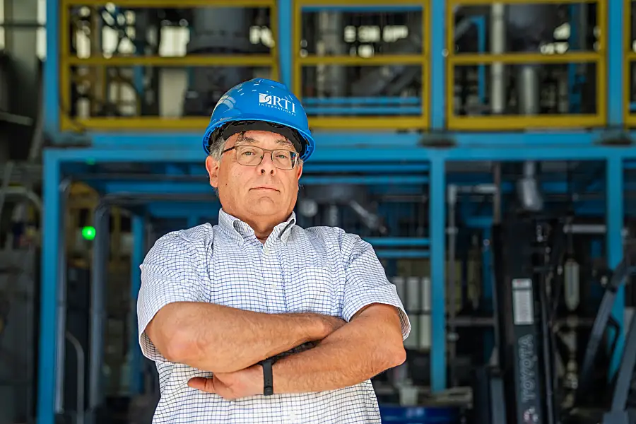 David Dayton wearing an RTI-branded hard hat with his arms crossed