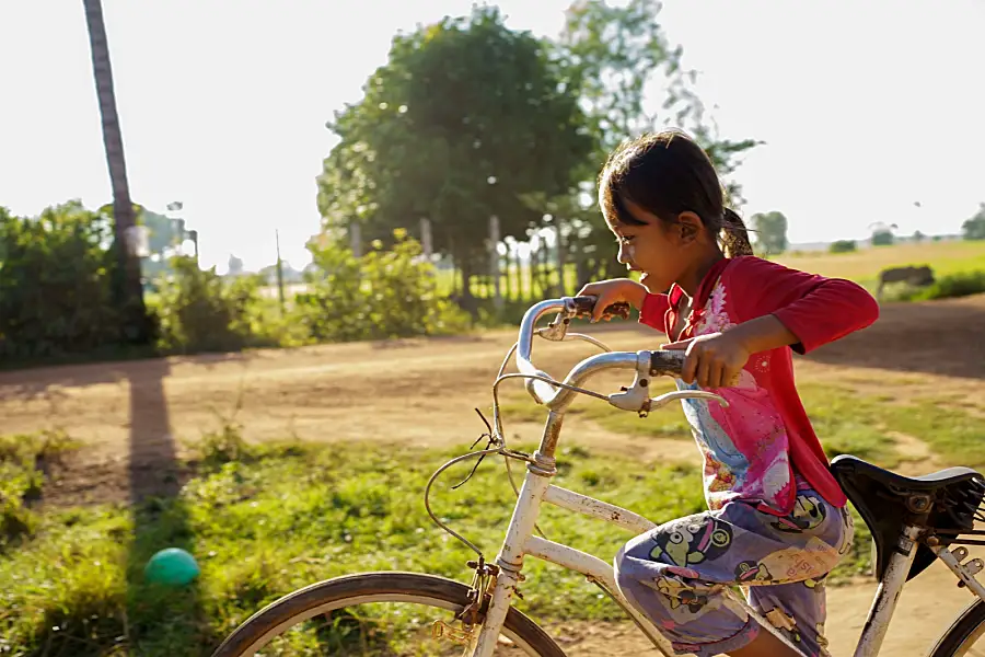 Photo of a young girl outside riding her bike