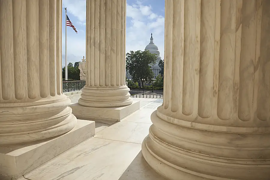 A view of the U.S. Capitol as seen from the columns of the Supreme Court building.