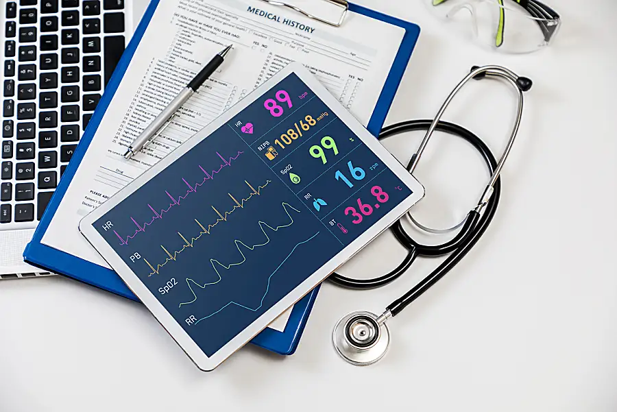 A display representing the transition to electronic health records, including a tablet showing a patient's vital signs and a clipboard of their medical history.