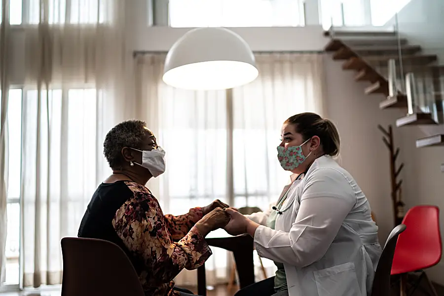 A home care nurse works with a senior patient.