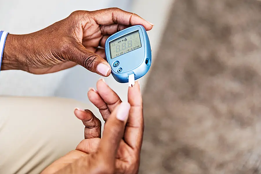 A woman uses a handheld device to measure her blood sugar level.