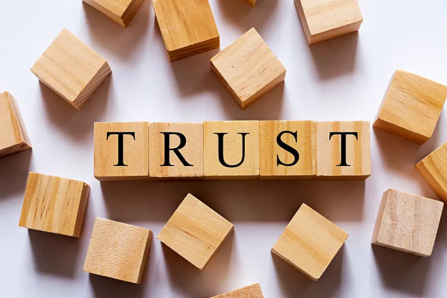 Square wooden blocks with letters spelling the word "trust"