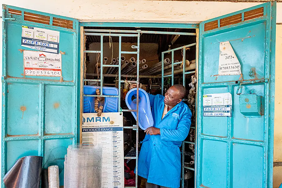 A sanitation worker in Kenya demonstrates equipment.