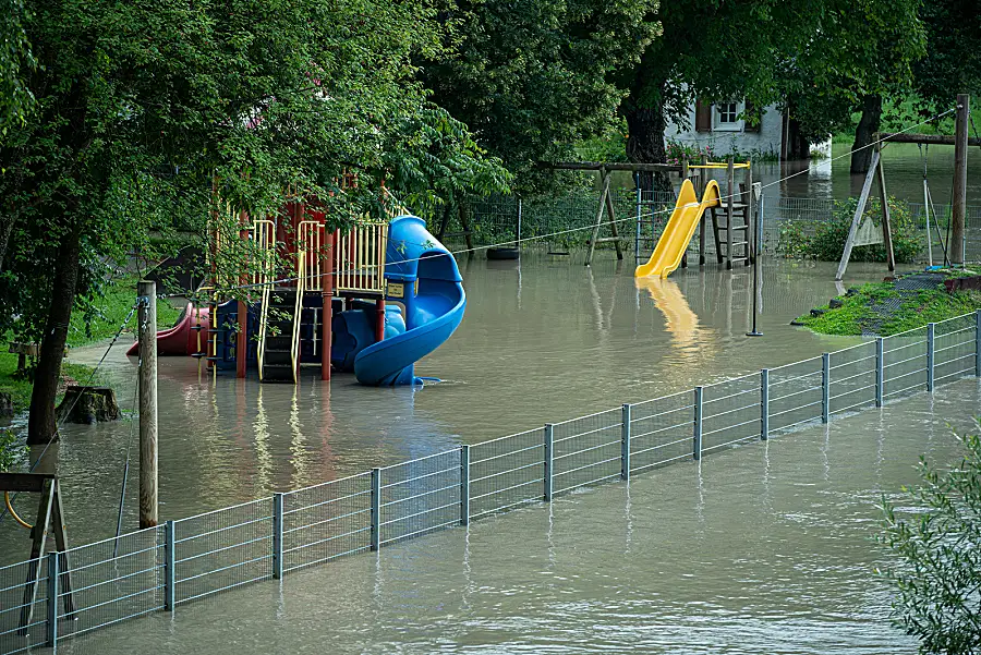 A school playground surrounded by floodwater.