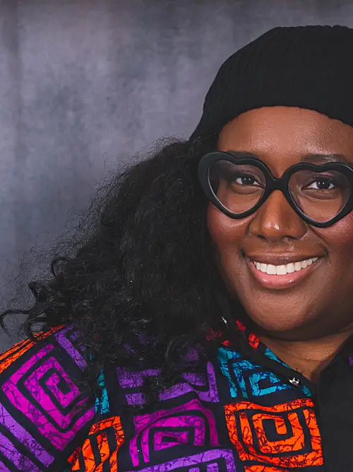 Headshot of Yewande Addie smiling against a grey background