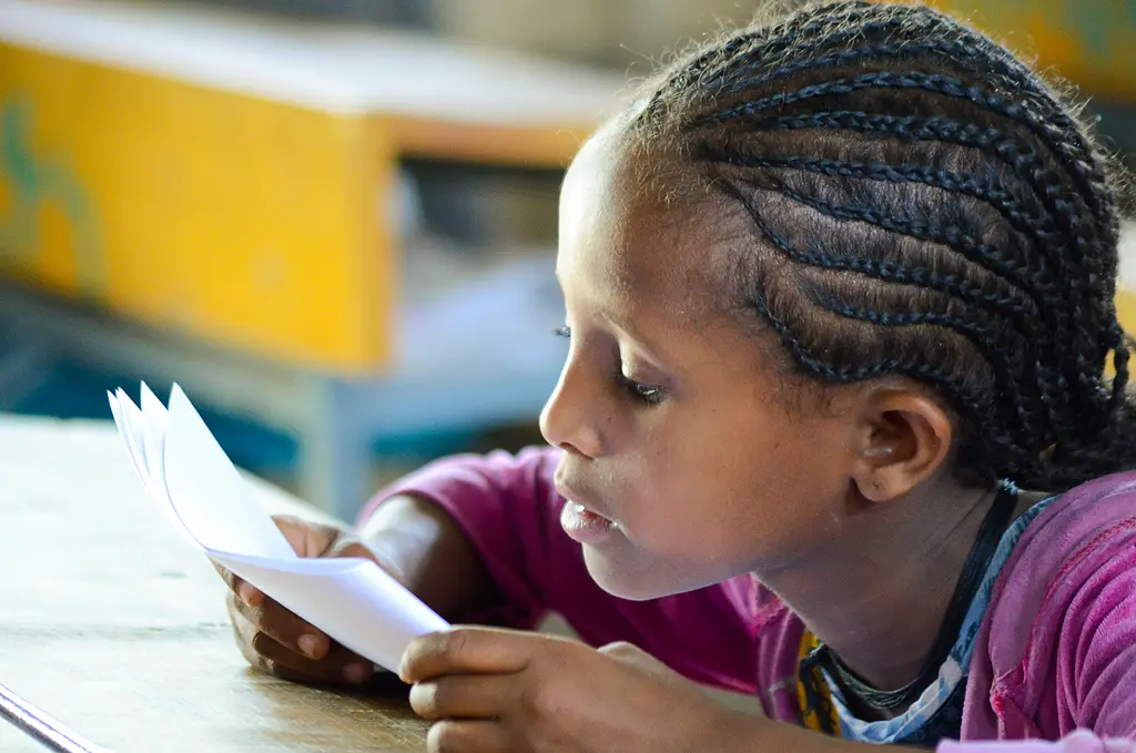 An Ethiopian girl reads from a paper in her classroom.