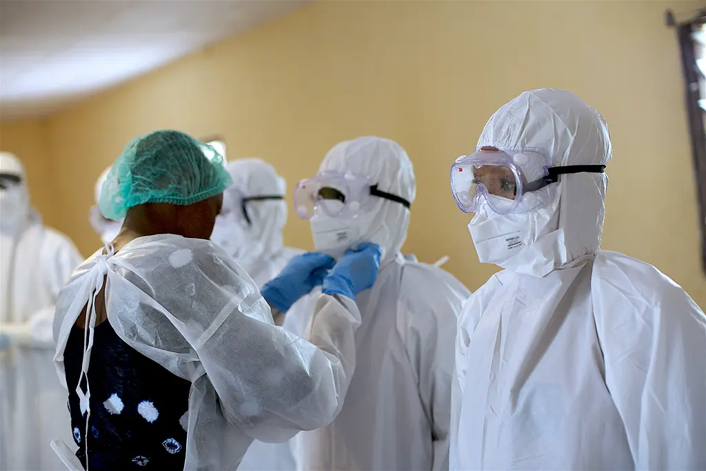 Health workers in Guinea don personal protective equipment to protect themselves during the Ebola outbreak from 2014-2016.