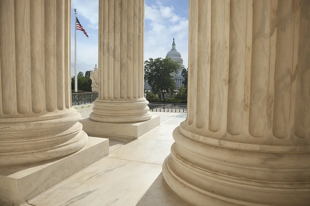 A view of the U.S. Capitol as seen from the columns of the Supreme Court building.