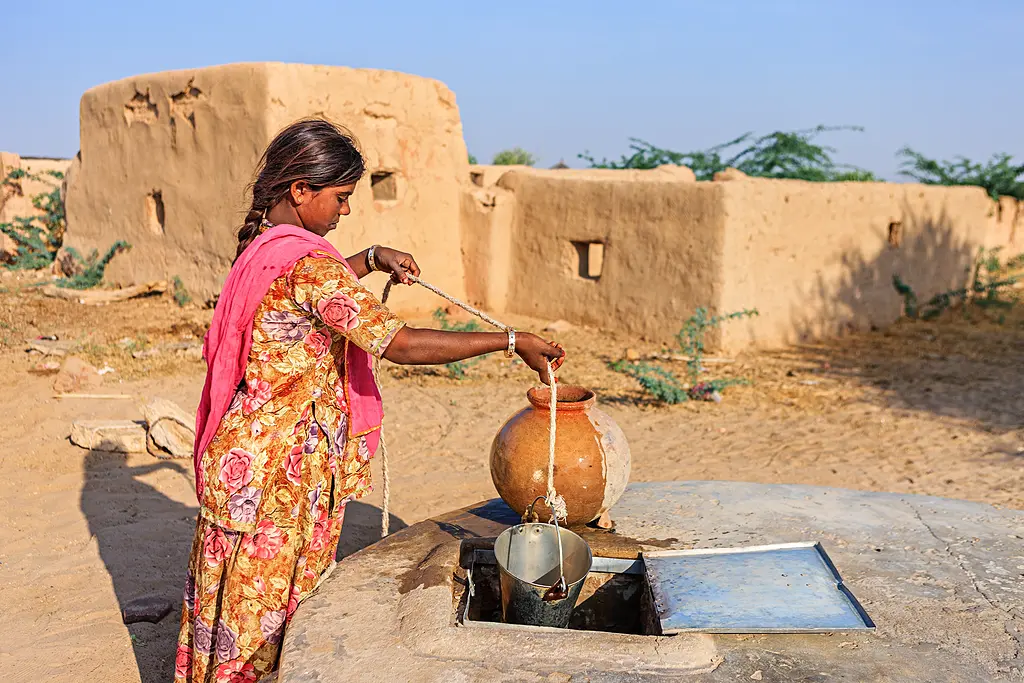 Indian girl taking water from well