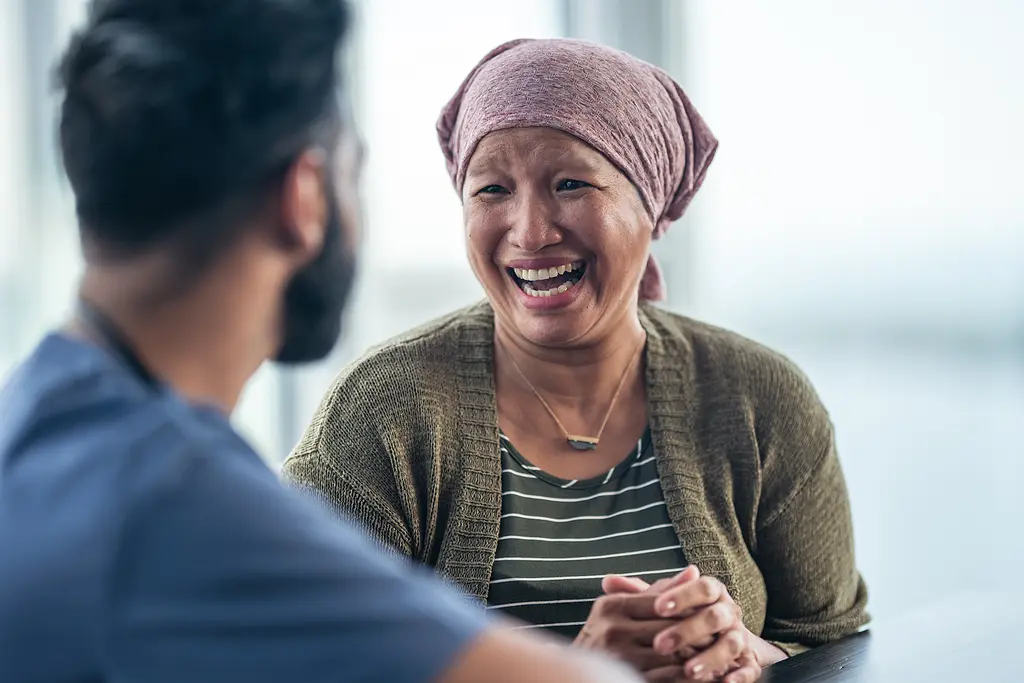 Woman with cancer talking to doctor laughing