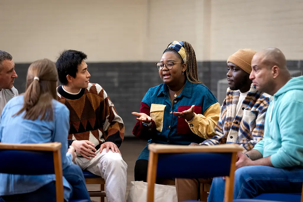 A group of people sitting in a circle and talking