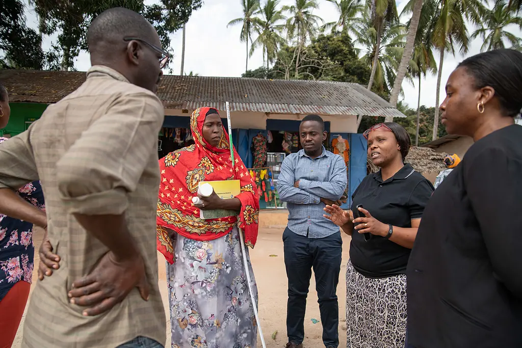 Dr. Faraja Lyamuya, LF Focal Person for the Ministry of Health in Tanzania, consulting with community health workers during a LF treatment campaign in Kilwa District, Tanzania