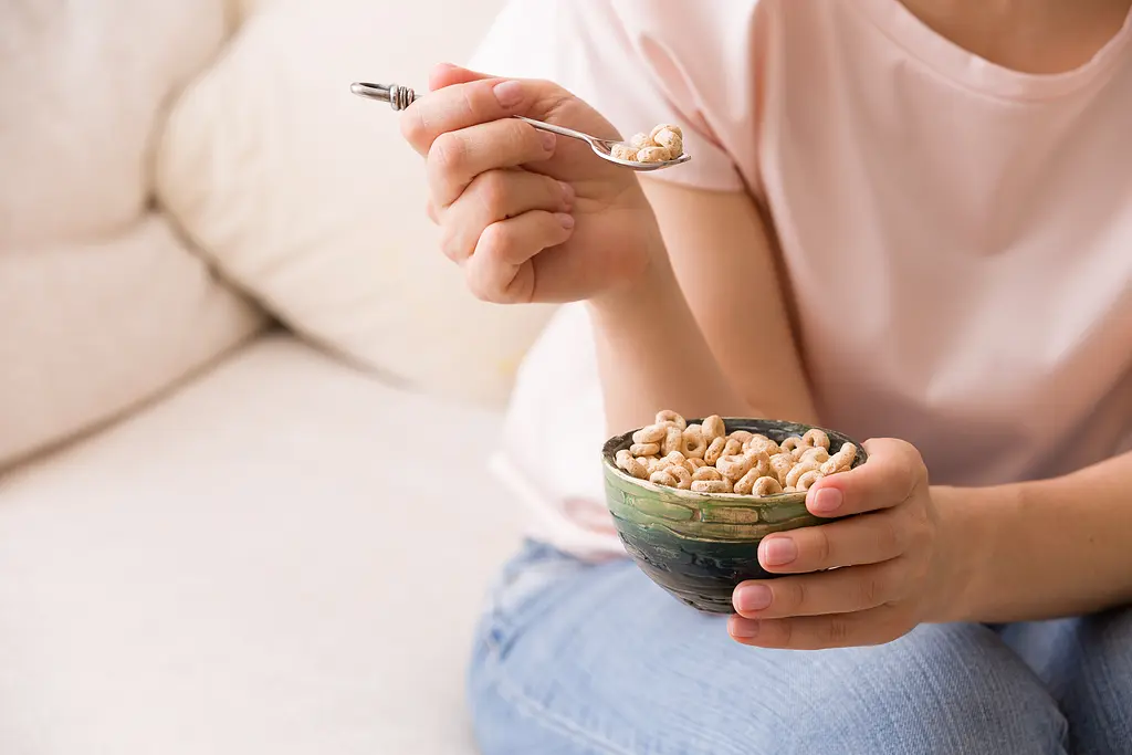 Closeup photo of a woman's hands holding bowl with Cheerios