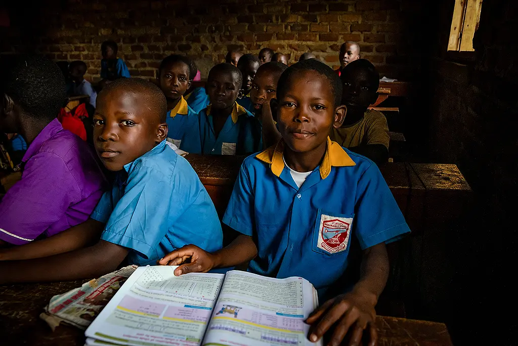 African students wearing school uniforms in a classroom.