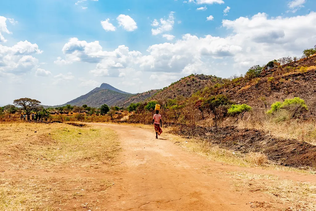 Ugandan woman walks alone on a rural road
