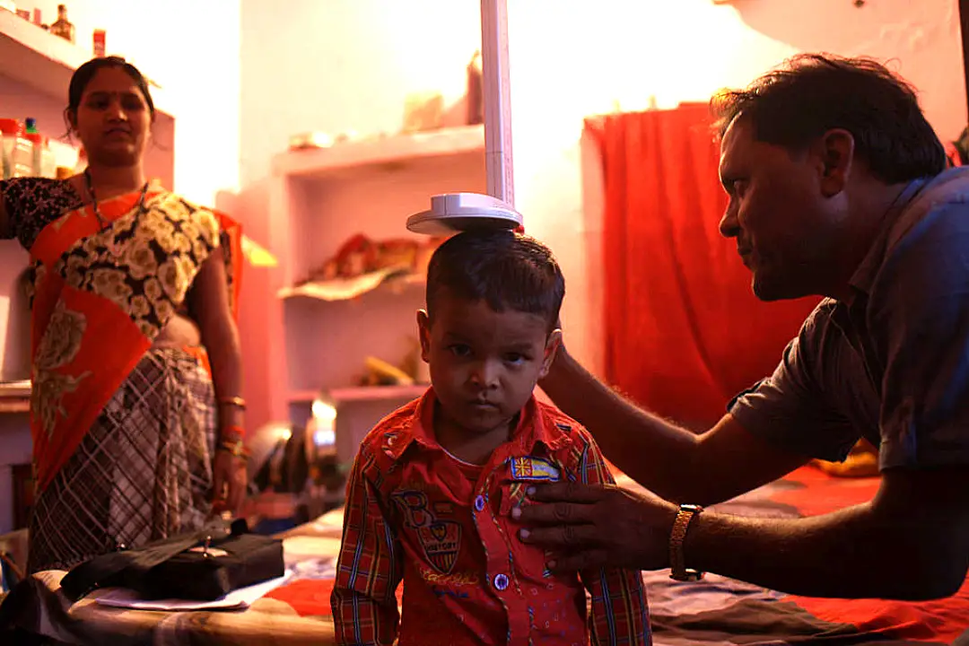 An Indian boy has his height measured during a health visit.