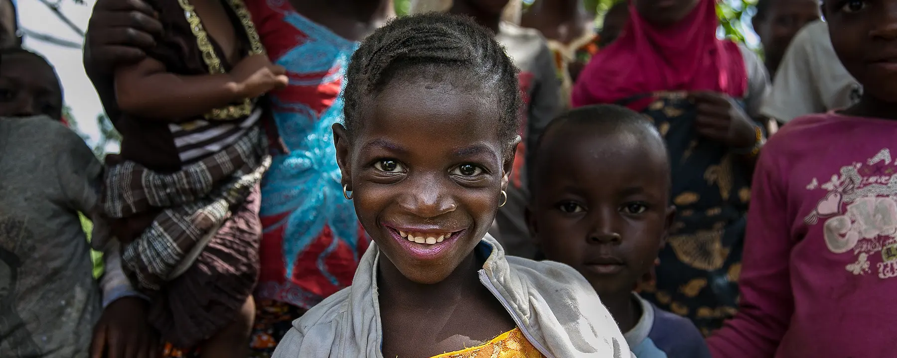 Girl in Kalan, Guinea smiles at the camera.