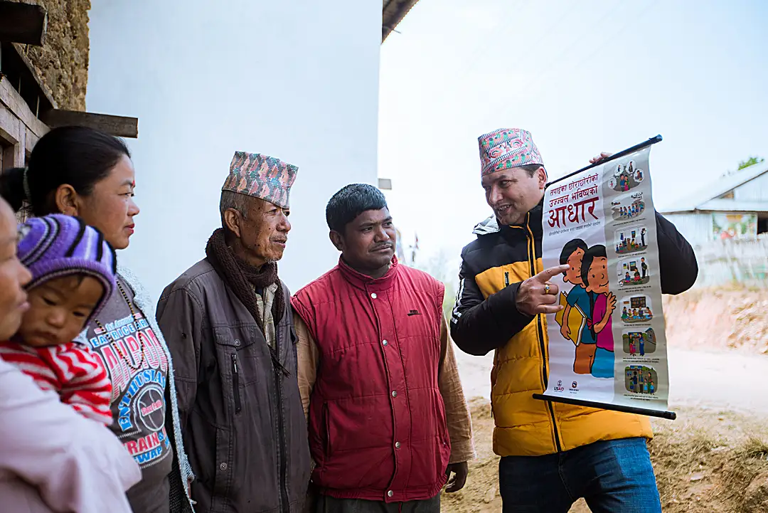 A peer educator in Nepal explains the EGRP program to community members and encourages involvement in children’s learning.