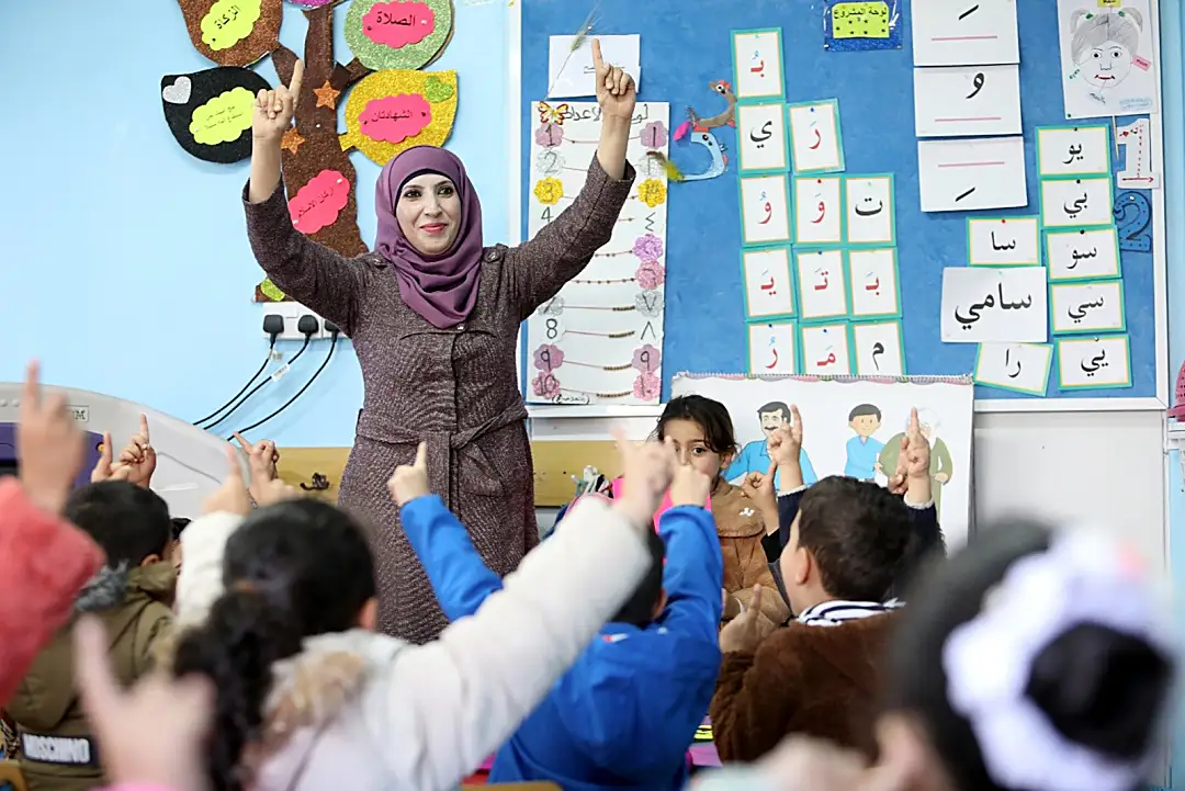 Tasneem Mohammad, a Jordanian teacher in the RAMP program, works with students.