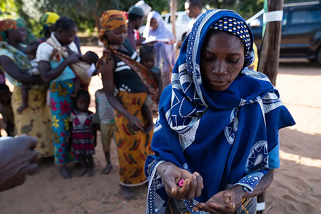 A woman holds pills being distributed as part of the effort to eliminate neglected tropical diseases in Mozambique.