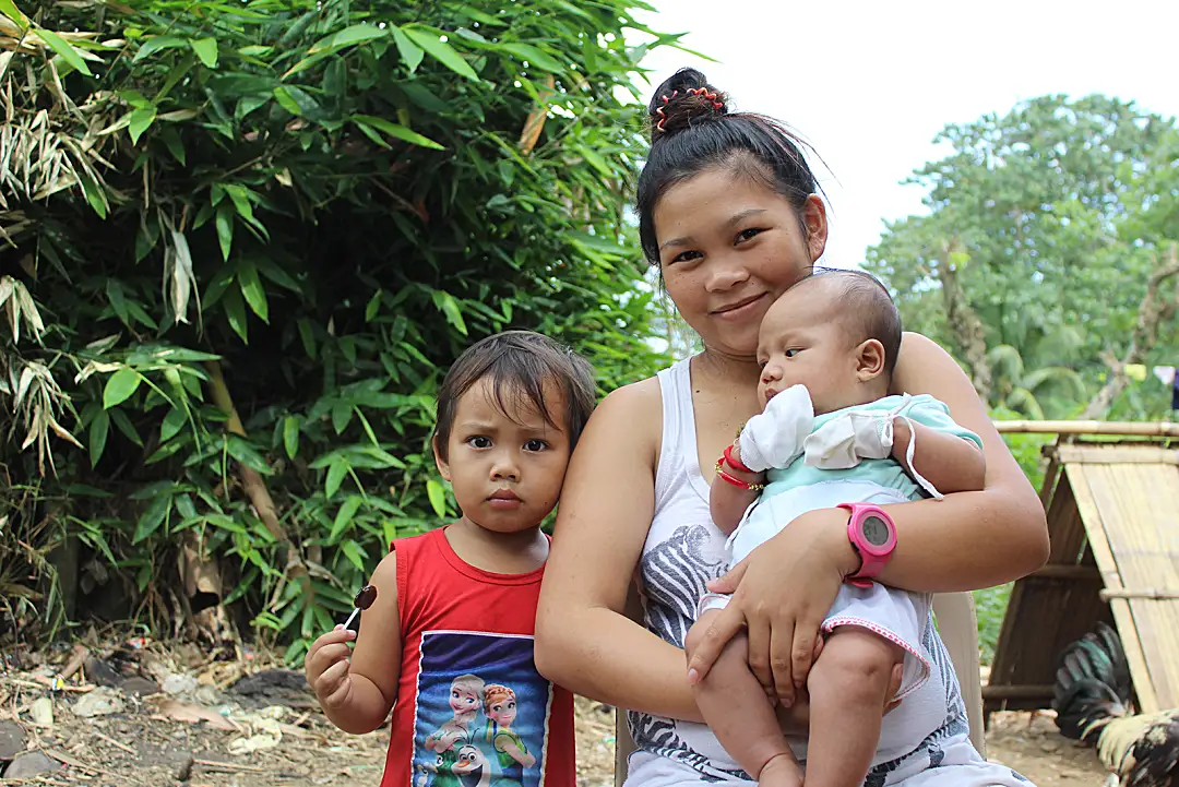 A teen mother and her children in the Philippines.