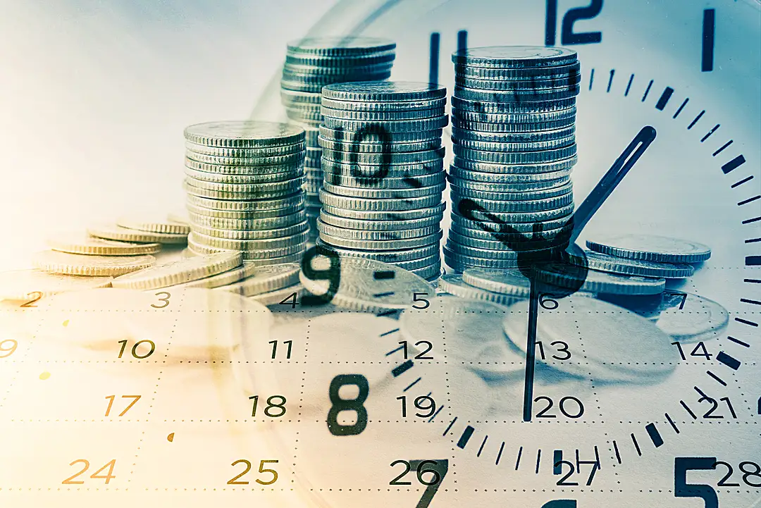 An illustration of a clock face superimposed over stacks of coins.