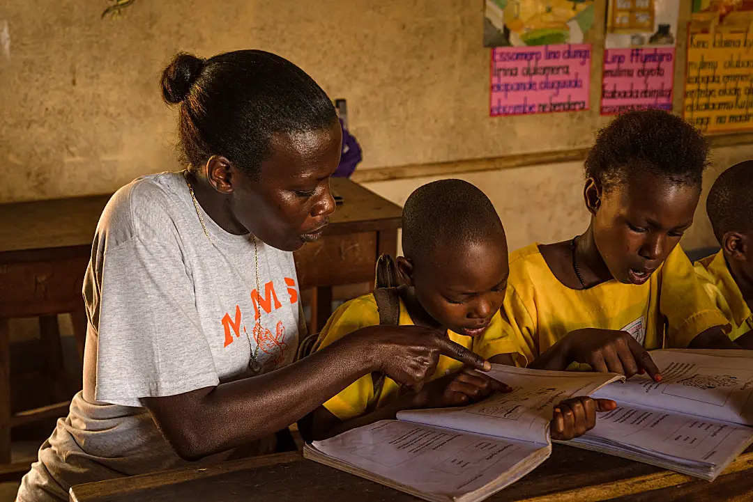 A teacher works with a group of upper primary students.