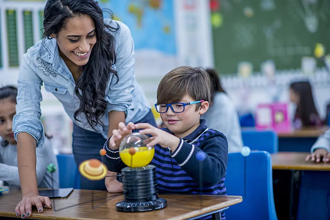 Male student getting help from female teacher