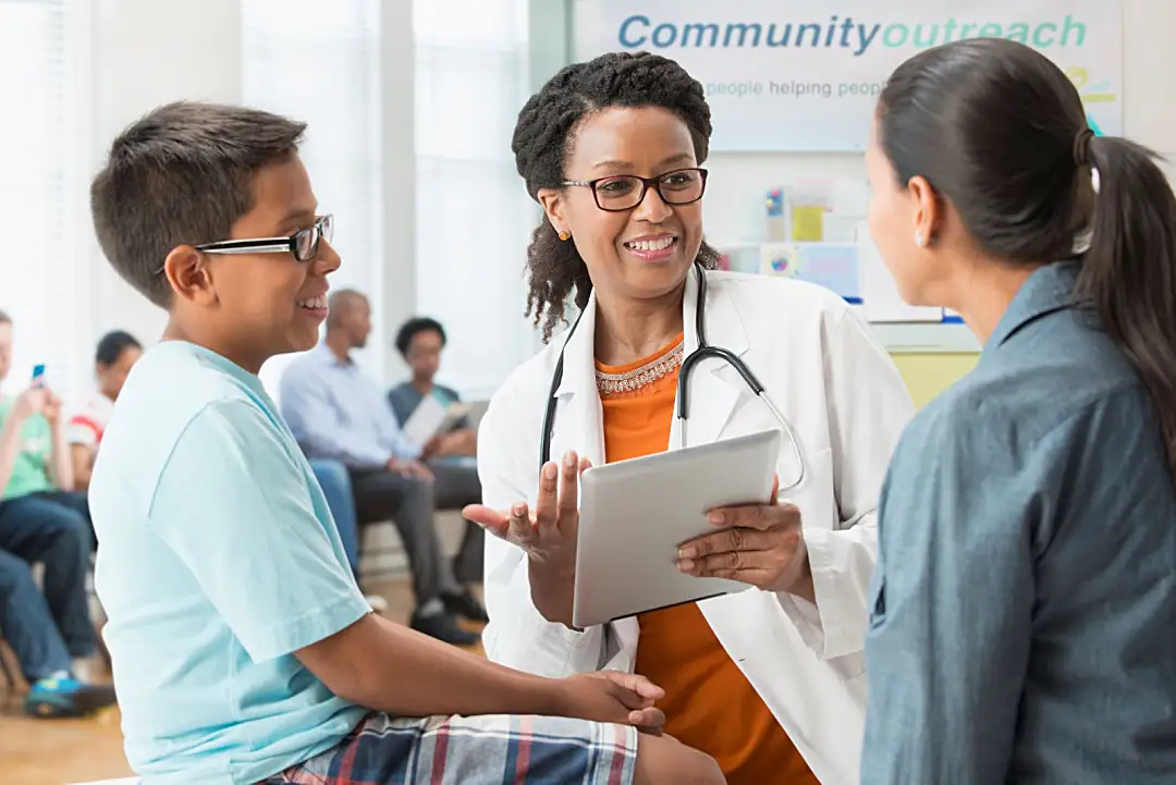 Doctor talking with a mother and child at community health clinic