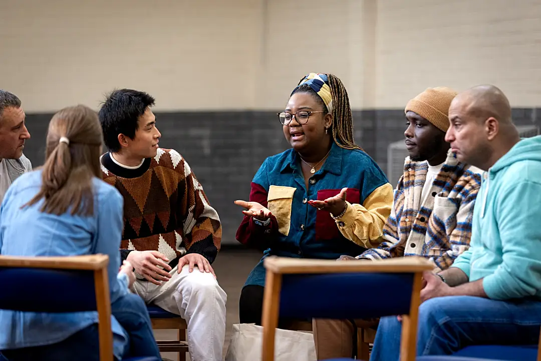 A group of people sitting in a circle and talking