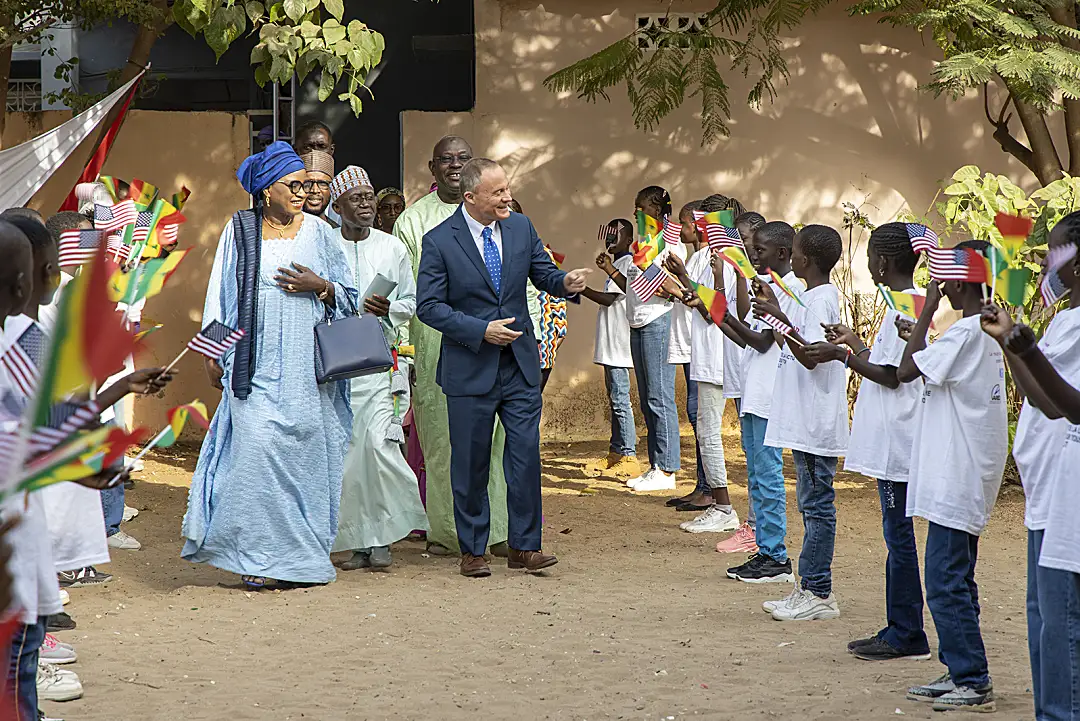 Schoolchildren in Senegal greet officials from the Ministry of Education.