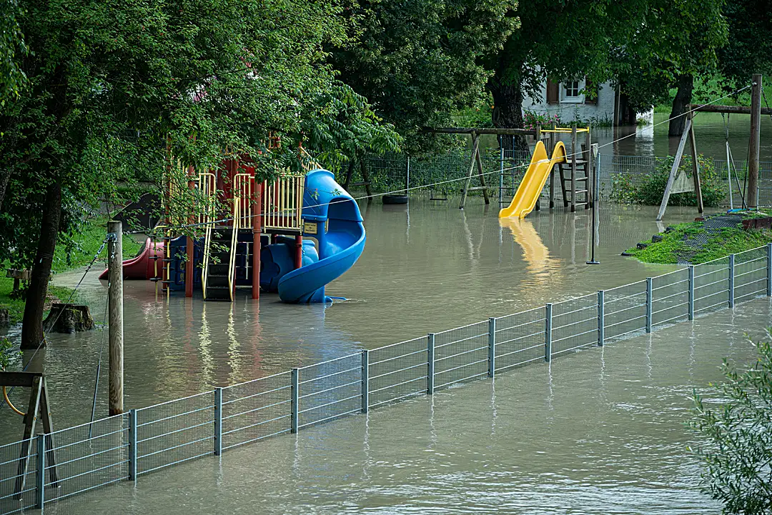 A school playground surrounded by floodwater.