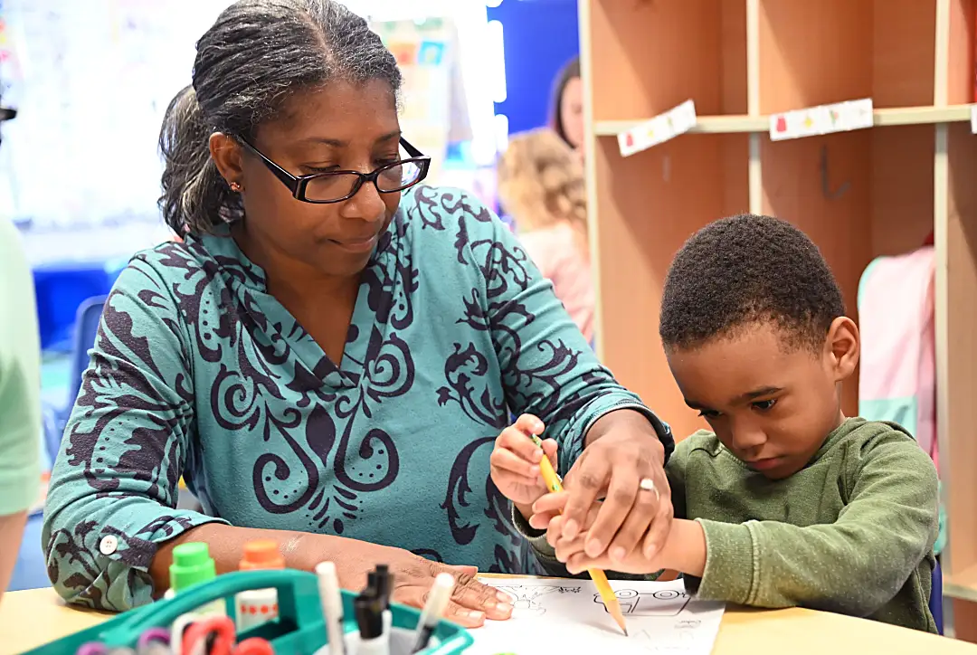 female educator helping elementary student