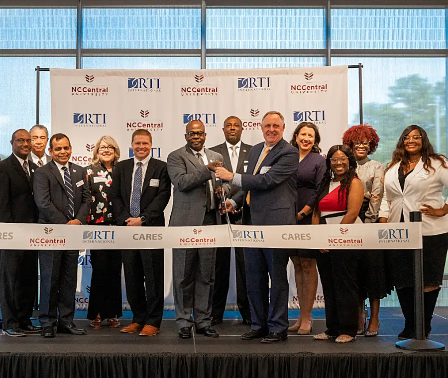 A group of people participate in a ribbon-cutting ceremony for NC Central University.