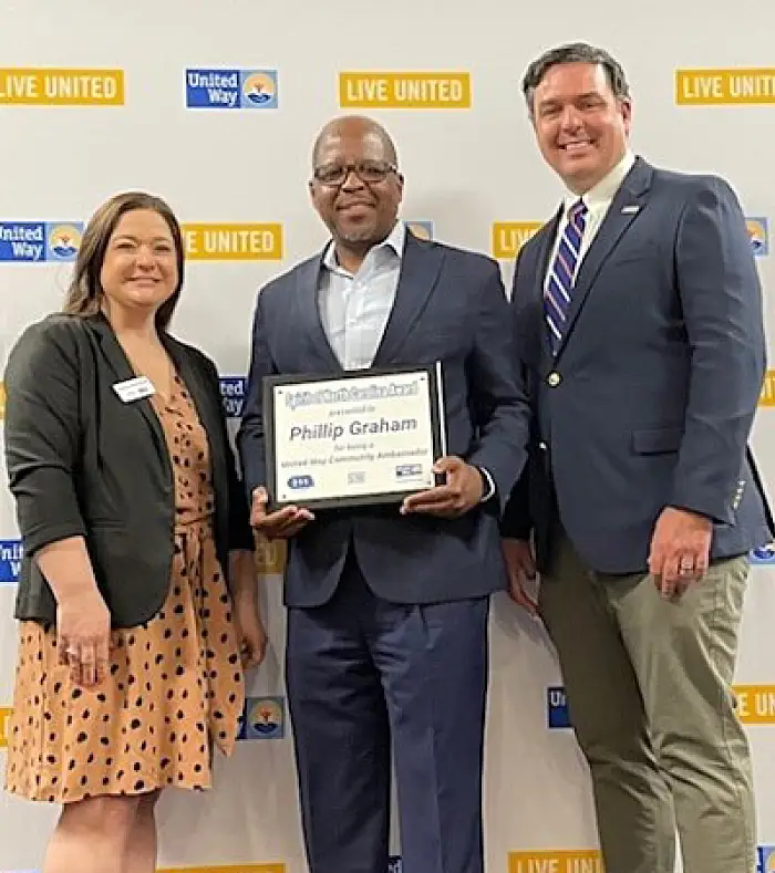 Phillip Graham holding the 2024 Spirit of NC Award United Way