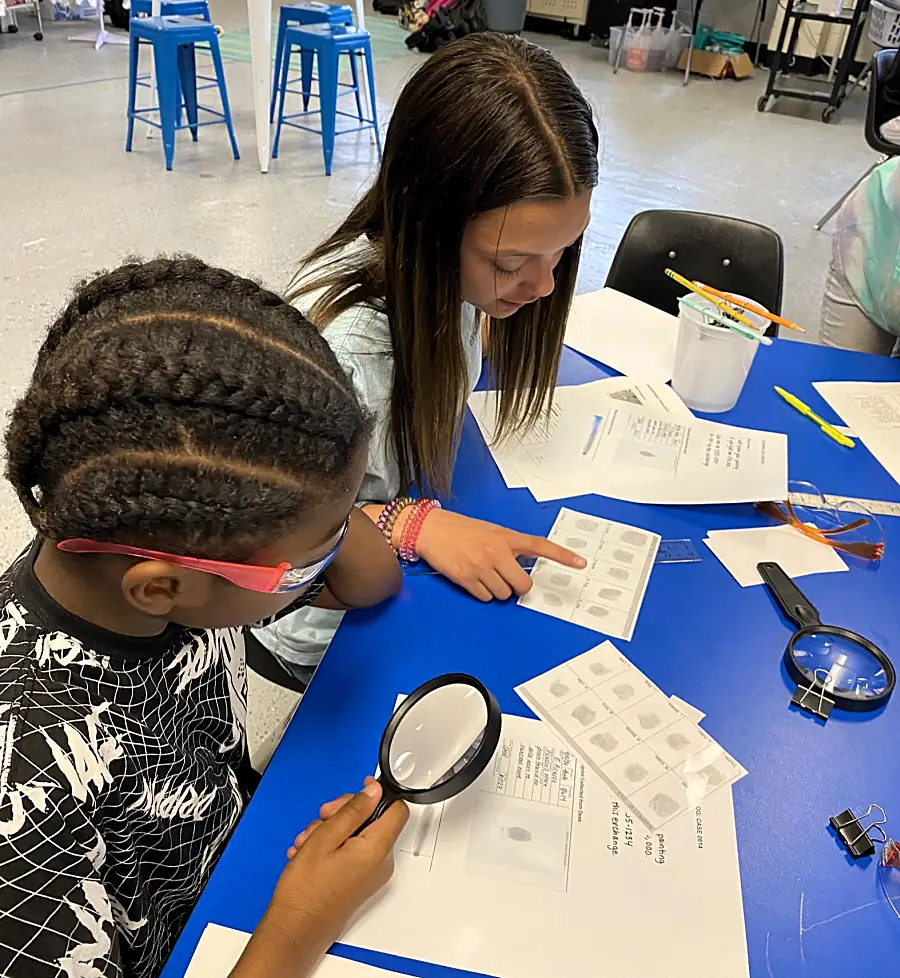 Two students study papers to solve a mystery