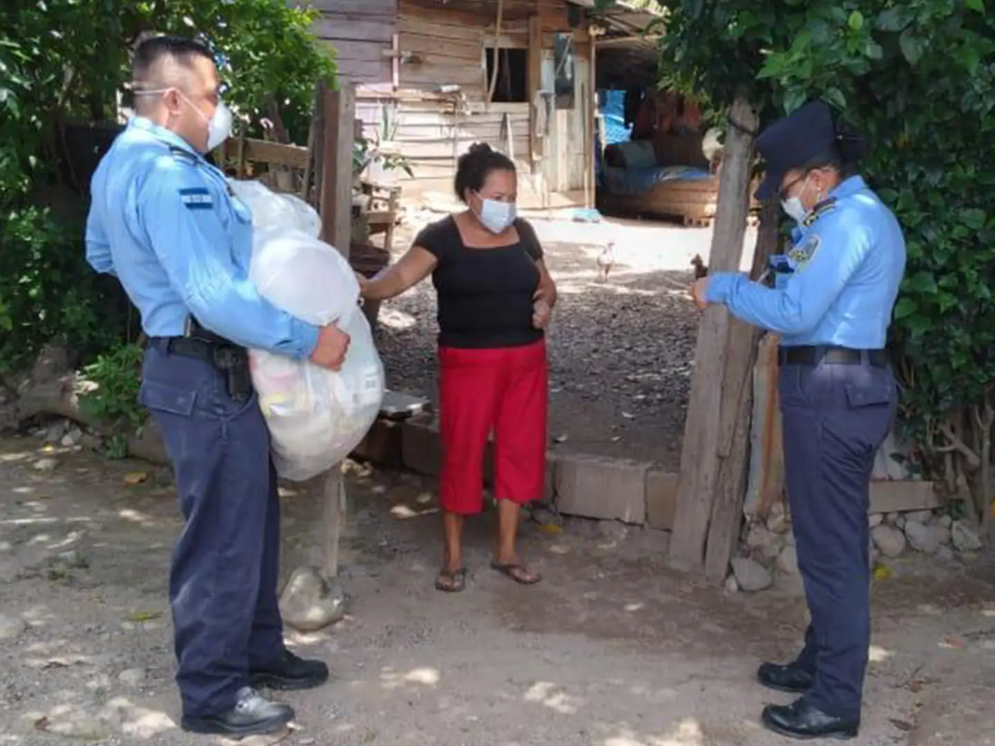 Police officers in Honduras hand out bags of groceries as part of a COVID-19 relief effort.