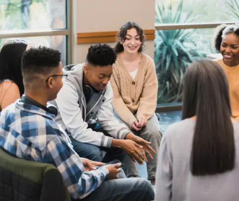 Teenagers seated in circle