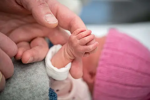 Holding newborn baby's hand