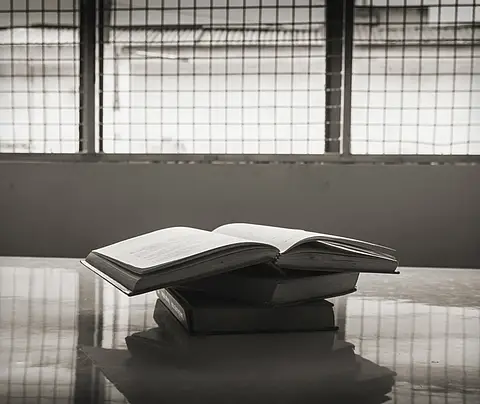opened book on table resting on stack