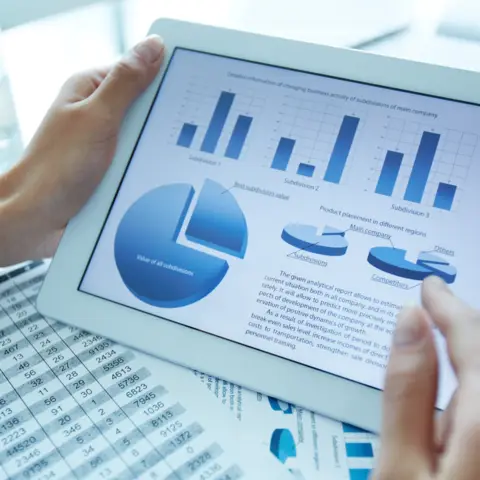 Person holding iPad with statistics on the screen
