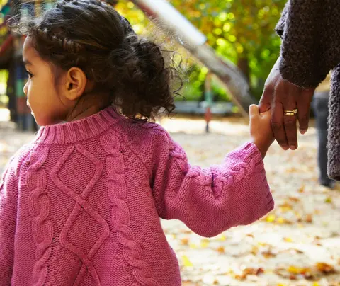 Child holding hands with parent