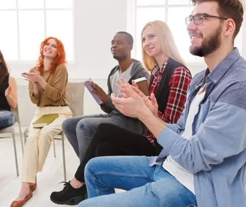 Individuals attend group therapy for addiction