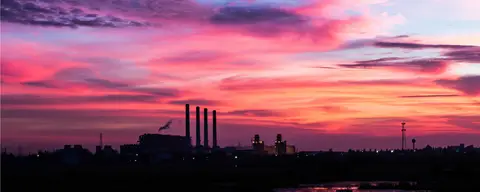 A landscape at sunset with a factory